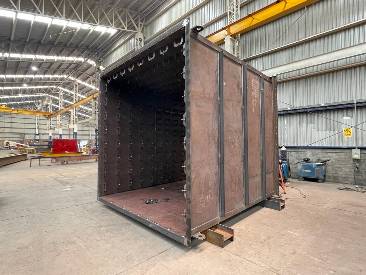 Interior of a raw transformer tank shell showing welded stud pattern