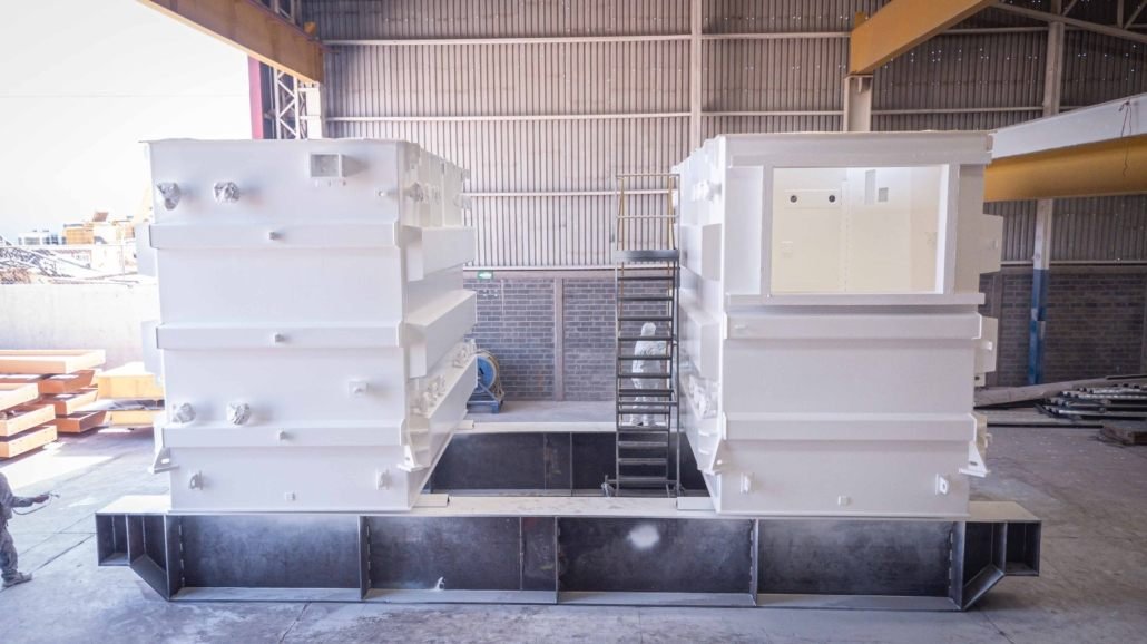 Two finished white transformer tanks in the plant